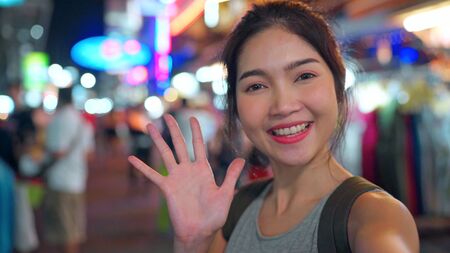 Traveler Asian blogger woman travel in Bangkok, Thailand, beautiful female using mobile phone make vlog and live in social media while hangout at The Khao San Road. Women travel in Thailand concept.の写真素材