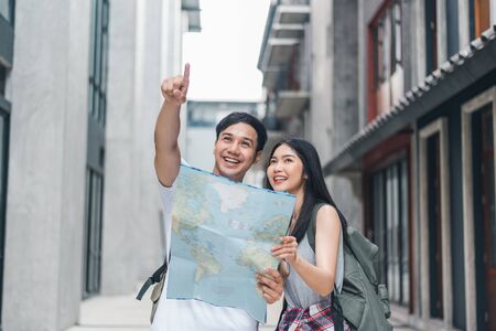 Traveler Asian couple direction on location map in Beijing, China, sweet Asia couple looking on map find landmark while spending holiday trip. Lifestyle couple travel in city concept.の写真素材