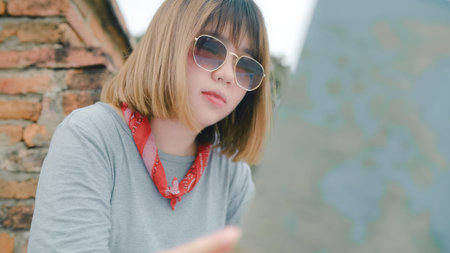 Traveler Asian woman direction and looking on location map while spending holiday trip at Ayutthaya,...