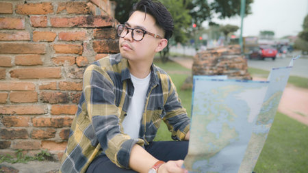 Traveler Asian man direction and looking on location map while spending holiday trip at Ayutthaya,...