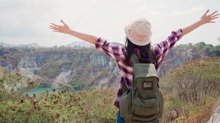 Hiker Asian backpacker woman walking to top of mountain, Female enjoy her holidays on hiking adventure feeling freedom. Lifestyle women travel and relax in free time concept.の写真素材