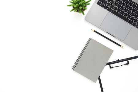 Creative flat lay photo of workspace desk. Top view office desk with laptop, pencil, notebook and plant on white color background. Top view with copy space, flat lay photography.の写真素材