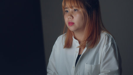 Young asian woman working late using desktop on desk in living room at home. Asia business woman...