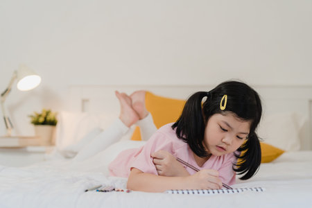 Young Asian girl drawing at home. Asia japanese woman child kid relax rest fun happy draw cartoon in...