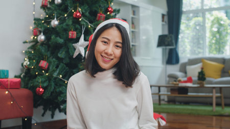 Asian women celebrate Christmas festival. Female teen wear Christmas hat relax happy smiling looking...