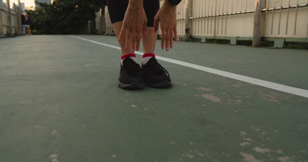 Beautiful young Asia athlete lady exercises doing stretch work out in urban environment. Japanese...