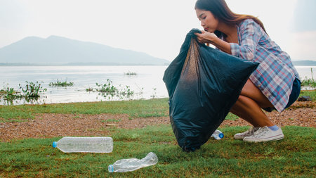 Happy young Asia activists collecting plastic waste on the beach. Korean lady volunteers help to...