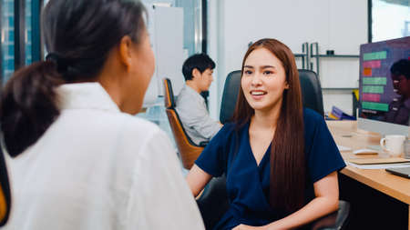 Asia businesspeople chatting to intern discussing job interview colleagues having conversation and communication meeting brainstorming ideas about project working plan success strategy in office.の写真素材