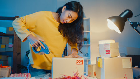 Young Asia businesswoman prepare product use tape packing box for send to customer purchase order in...