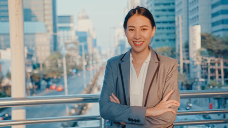 Successful young Asia businesswoman in fashion office clothes smiling and looking at camera while...