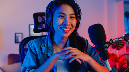 Happy asia girl blogger music influencer looking at camera broadcast record wear headphone online...