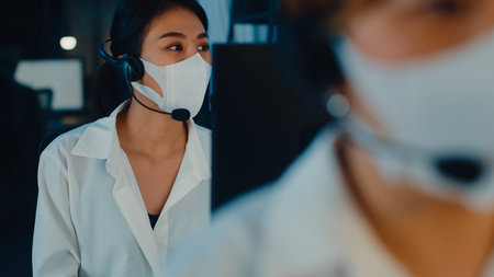 Millennial Asia young call center team or customer support service executive wearing face mask...