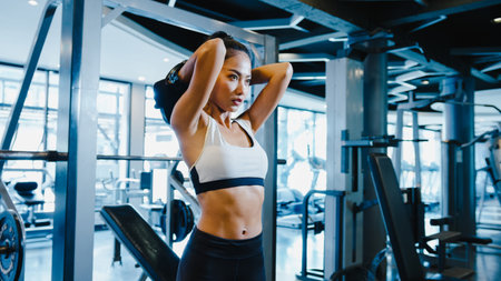 Beautiful young Asia lady exercise doing lifting barbell fat burning workout in fitness class. Athlete with six pack, Sportswoman recreational activity, functional training, healthy lifestyle concept.の写真素材