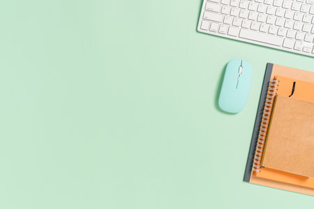 Minimal work space - Creative flat lay photo of workspace desk. Top view office desk with keyboard, mouse and book on pastel green color background. Top view with copy space, flat lay photography.の写真素材