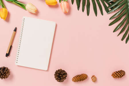 Creative flat lay of travel vacation spring or summer tropical fashion. Top view beach accessories open mockup black notebook for text on pastel background. Top view mock up copy space photography.の写真素材