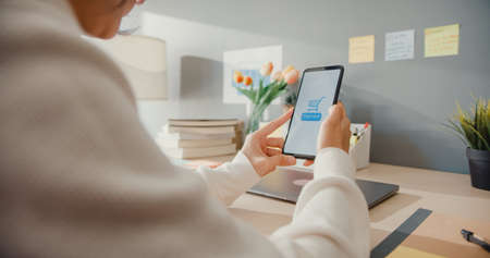 Young asia lady use cellphone order online shopping product and paying bills with banking app with transaction successful. Stay at house, Quarantine activity, Fun activity for coronavirus prevention.の写真素材