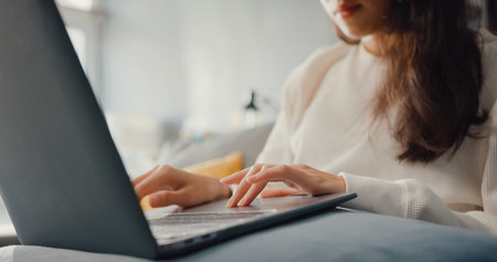 Closeup freelance Asia lady casual wear using laptop online learn in living room at house. Start...
