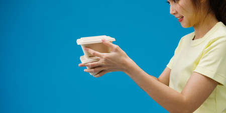 Young woman hand hold brown clear empty blank craft paper box food for takeaway over blue background. Copy space for place a text for advertisement. Advertising area, mock up promotional content.の写真素材