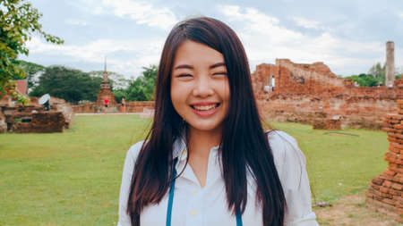 Cheerful beautiful young Asian backpacker blogger woman casual with camera take photo smiling traveling around pagoda at the old city, Lifestyle backpack tourist travel holiday concept. Point of view.の写真素材