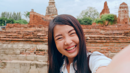 Close-up Young Asian backpacker blogger woman casual look camera video call on smartphone share live online for audience travel together at pagoda old city, Lifestyle tourist travel holiday concept.の写真素材