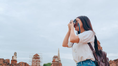 Traveler Asian woman using camera for take a picture while spending holiday trip at Ayutthaya,...