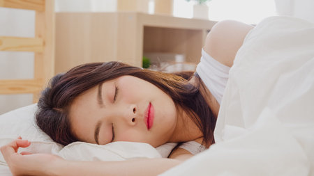 Asian woman dreaming while sleeping on bed in bedroom, Beautiful japanese female using relax time...