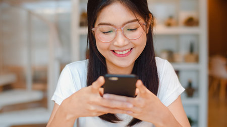 Freelance Asian women using mobile phone at office. Young Japanese Asia Girl using smartphone...