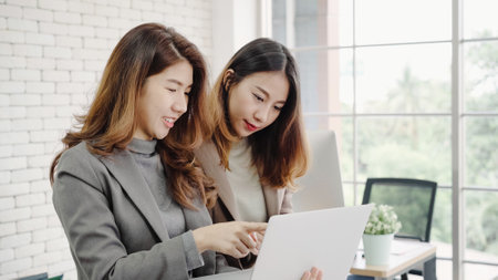 Beautiful young asian women LGBT lesbian happy couple sitting on bed hug and using phone taking selfie together bedroom at home. LGBT lesbian couple together indoors concept. Spending nice time home.の写真素材