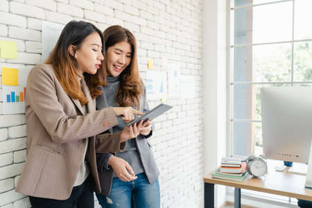 Beautiful young asian women LGBT lesbian happy couple sitting on bed hug and using phone taking selfie together bedroom at home. LGBT lesbian couple together indoors concept. Spending nice time home.の写真素材