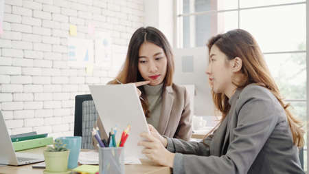 Beautiful young asian women LGBT lesbian happy couple sitting on bed hug and using phone taking selfie together bedroom at home. LGBT lesbian couple together indoors concept. Spending nice time home.の写真素材