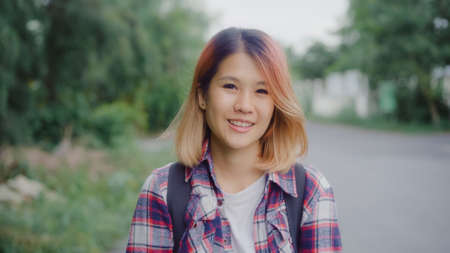 Asian hiker woman trekking in forest. Young happy backpack girl smiling to camera, travel nature and adventure trip, climb mountain lot of tree in spring holidays vacation concept.の写真素材