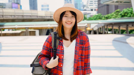 Attractive young smiling Asian woman outdoors portrait in the city real people series. Outdoors lifestyle fashion portrait of happy smiling Asian girl. Summer outdoor happiness portrait concept.の写真素材