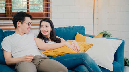 Asian influencer women using camera streaming and recording vlog video about the benefit of drinking milk and sandwiches for breakfast on sofa in living room at home for broadcast online.の写真素材