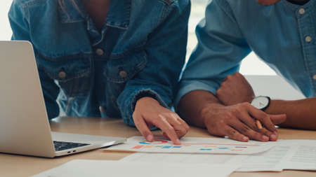 Young Asian creative team meeting working on laptop. Group of business man and woman looking document paper, discuss and think new idea, business situation, teamwork in modern office concept.の写真素材
