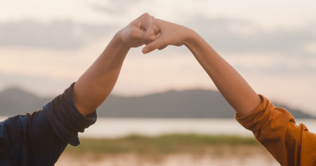 Young asia campers couple camping near seaside. Male and female traveler using smartphone vlog video and live in social media at campsite. Outdoor activity, adventure travel, or holiday vacation.の写真素材