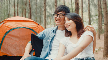 Asian hiker couple trekking in forest. Young happy backpack male and female walking enjoy her journey, travel nature and adventure trip, climb mountain lot of tree in fall holidays vacation concept.の写真素材