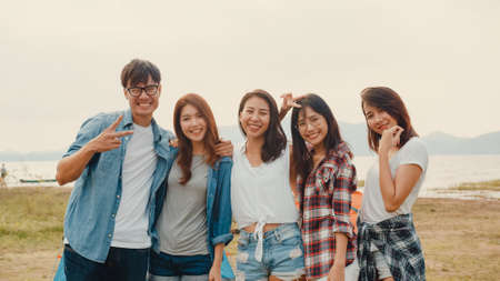 Group of Asia best friends teenagers lady dancing and drinking have fun salute toast of bottle beer enjoy party with happy moments together in campsite at night. Beautiful camping traveller concept.の写真素材