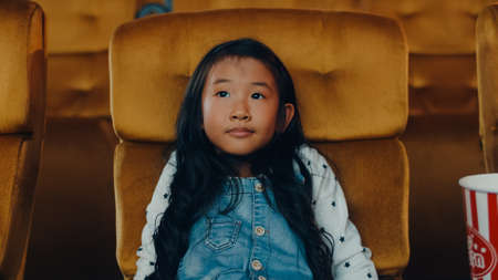 Attractive cheerful young asian girl laughing while watching film in movie theater. Lifestyle entertainment concept.の写真素材