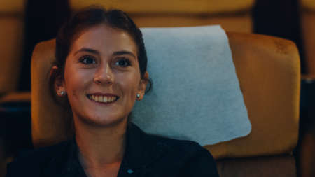 Attractive cheerful young caucasian lady laughing while watching film in movie theater. Lifestyle entertainment concept. Close up shot.の写真素材