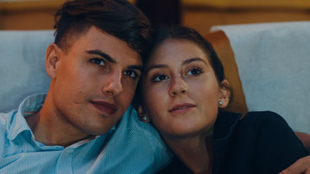 Attractive cheerful young caucasian couple kissing romantic moment while watching film in movie theater. Lifestyle entertainment concept.の写真素材