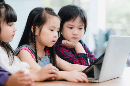 Group of children using laptop in classroom, Multi-ethnic young boys and girls happy using technology for study at elementary school. Kids use technology for education concept.の写真素材