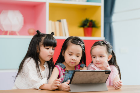 Group of children using tablet in classroom, Multi-ethnic young boys and girls happy using technology for study and play games at elementary school. Kids use technology for education concept.の写真素材