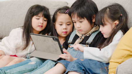 Group of children using tablet in classroom, Multi-ethnic young boys and girls happy using technology for study and play games at elementary school. Kids use technology for education concept.の写真素材
