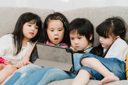 Group of children using tablet in classroom, Multi-ethnic young boys and girls happy using technology for study and play games at elementary school. Kids use technology for education concept.の写真素材