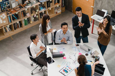 Multiracial group of young creative people in smart casual wear discussing business brainstorming meeting ideas mobile application software design project in modern office. Coworker teamwork concept.の写真素材