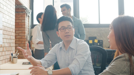 Multiracial group of young creative people in smart casual wear discussing business brainstorming meeting ideas mobile application software design project in modern office. Coworker teamwork concept.の写真素材