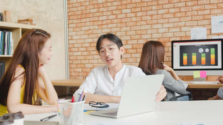Multiracial group of young creative people in casual wear meeting brainstorming ideas about new paperwork project colleagues working together planning success strategy enjoy teamwork in small officeの写真素材