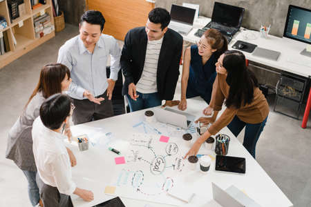 Multiracial group of young creative people in smart casual wear discussing business brainstorming meeting ideas mobile application software design project in modern office. Coworker teamwork concept.の写真素材