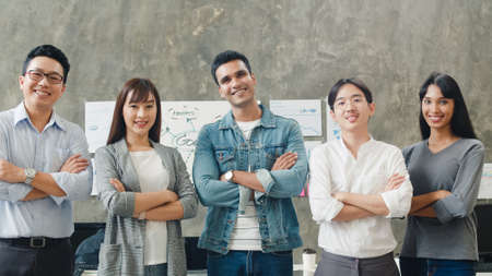 Portrait of successful businessman and businesswoman smart casual wear looking at camera and smile, arms crossed in creative office workplace. Diverse Asia male and female stand together at startup.の写真素材