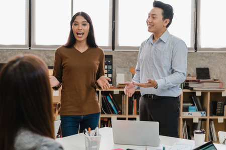 Multiracial group of young creative people in casual wear meeting brainstorming ideas about new paperwork project colleagues working together planning success strategy enjoy teamwork in small officeの写真素材
